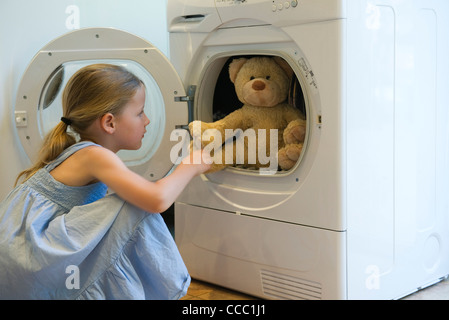 Petite fille prendre ours hors de cheveux Banque D'Images