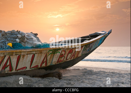 Bateau de pêche gambienne sur plage de Kololi au coucher du soleil, près de Banjul, Gambie, en Afrique de l'Ouest Banque D'Images