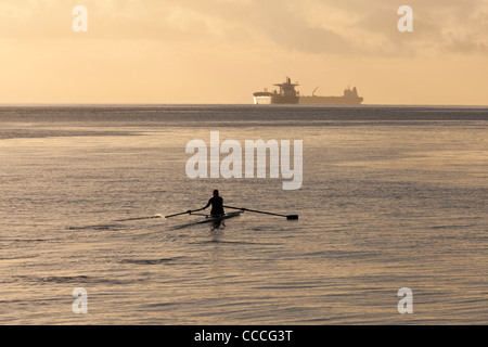 Un rameur dans un bateau skiff Banque D'Images