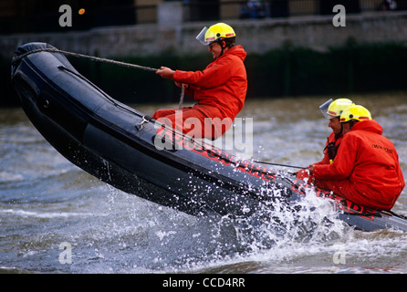 Sautant par-dessus les vagues, London Fire Brigade (BF) les pompiers s'entraînent sur la Tamise à l'aide d'un canot pneumatique Banque D'Images