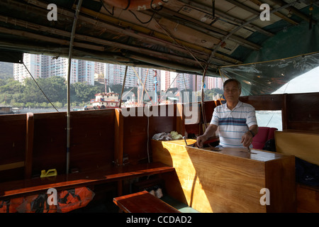 Chinese man driving voyage en bateau sampan à Aberdeen Harbour hong kong Hong Kong Chine Asie Banque D'Images