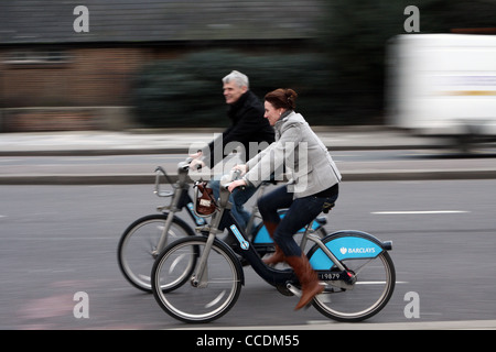 Un homme et de la femme Boris Bikes à Londres Banque D'Images