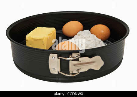 Photo détail d'un moule à charnière noire qui y sont, le beurre, la farine et trois oeufs Banque D'Images