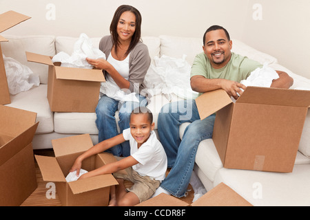 African American Family, parents et fils, déballage des boîtes et de déménager dans une nouvelle maison, les adultes sont déballage articles menagers Banque D'Images