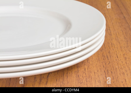 Quatre plaques blanches sur table en bois Banque D'Images