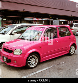 Voiture rose individualité à Melaka en Malaisie en Extrême-Orient Asie du sud-est. Les couleurs vives des voitures colorées voyage féminin urbain Banque D'Images