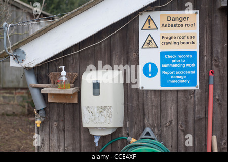 Un signe d'avertissement du danger de grimper sur un toit fragile de l'amiante. Photo par Pete Gawlik. Banque D'Images
