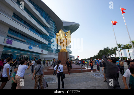 Des touristes posent pour des photos à l'extérieur de la statue Golden Bauhinia hong kong Convention and Exhibition Centre de Hong Kong Chine Asie Banque D'Images