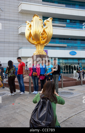 Des touristes posent pour des photos à l'extérieur de la statue Golden Bauhinia hong kong Convention and Exhibition Centre de Hong Kong Chine Asie Banque D'Images