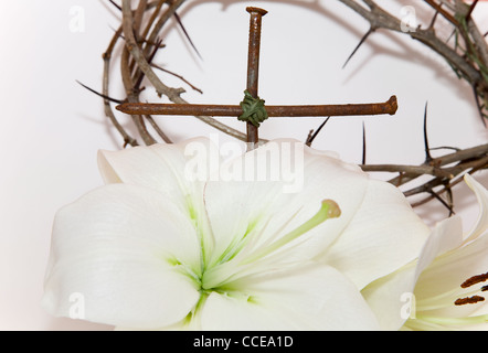 Couronne d'épines, crucifix et Pâques lys blanc sur fond blanc Banque D'Images