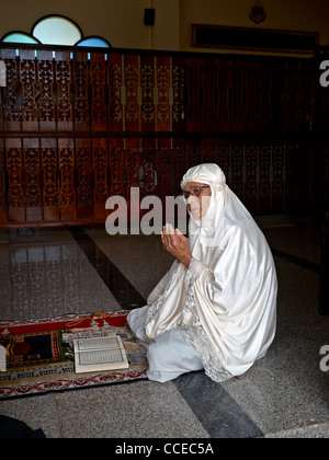 Femme thaïlandaise musulmane de 90 ans priant et portant une burka traditionnelle blanche Banque D'Images