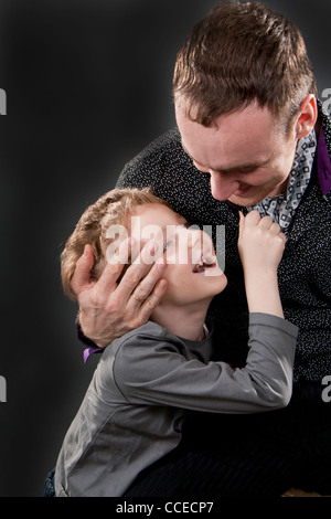 Père et fils parler gaiement. Sur un fond gris. Boy in focus. pas Banque D'Images