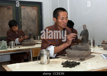 Sculpture artiste en costume national à l'Institut national des arts et métiers traditionnels Zorig Chusum, Thimphu, Bhoutan Banque D'Images