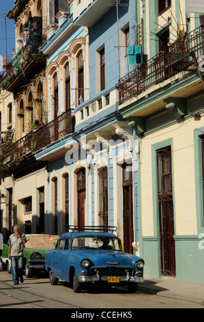 Vieille voiture bleue, l'homme de fumer et l'architecture coloniale, La Havane, Cuba Banque D'Images