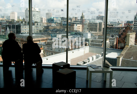 Deux femme assise face à Glasgow city scape à partir de la plate-forme d'observation à travers la fenêtre de verre Banque D'Images