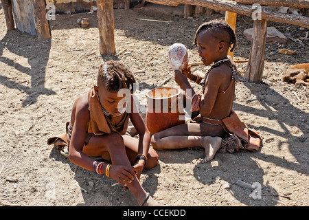 Les enfants de manger du gruau de maïs Himba dans village près d'Opuwo, Namibie Banque D'Images