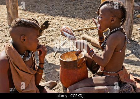 Les enfants de manger du gruau de maïs Himba dans village près d'Opuwo, Namibie Banque D'Images