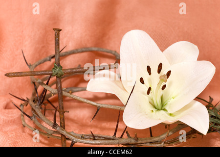 Couronne d'épines, crucifix et Pâques lys blanc sur fond beige Banque D'Images