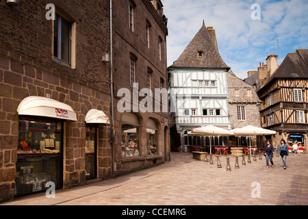 Scène de rue à Dinan, Bretagne France. Deux jeunes femmes à pied à travers le centre-ville, avec ses vieux bâtiments à colombages et c Banque D'Images