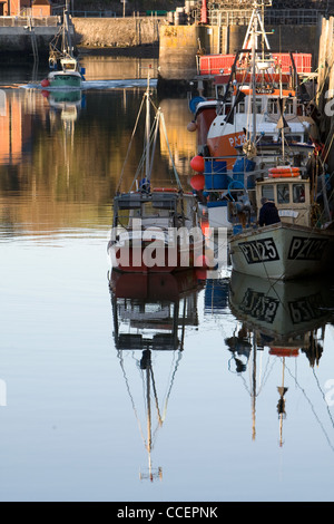 Un bateau entre dans le port de pêche de Padstow dans la lumière du soir. Banque D'Images