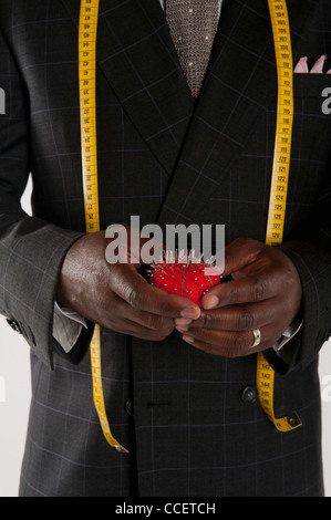 Mid section of man wearing suit holding pincushion Banque D'Images