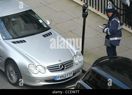 Un gardien de la circulation écrit un billet dans une rue de Londres. Photo par James Boardman. Banque D'Images