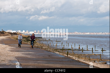 Deux femelles du vélo le long du mur de la mer sur la côte de l'île de Grain Banque D'Images