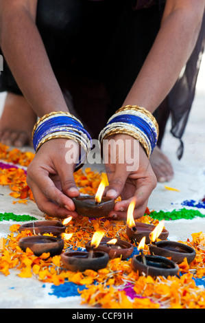 L'Inde girl ajout de lampes à huile à un festival de sankranthi Rangoli design. Puttaparthi, Andhra Pradesh, Inde Banque D'Images