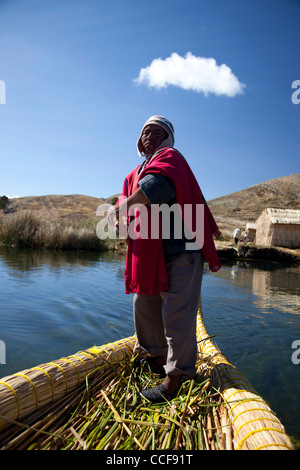 Un homme pousse un Aymara tortora reed sur le radeau du côté bolivien du Lac Titicaca, le lac navigable le plus élevé du monde. Banque D'Images