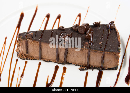 Gâteau au chocolat sur une plaque blanche arrosé de sauce au chocolat Banque D'Images