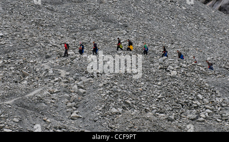 Les randonneurs à faire leur chemin sur une pierre couverte côté montagne Banque D'Images