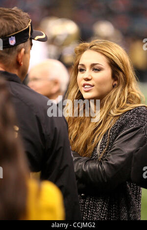 12 déc 2010 - LA NOUVELLE ORLÉANS, LOUISIANE, USA - La chanteuse et actrice MILEY CYRUS parle avec les Saints coach SEAN PAYTON en marge avant la Nouvelle Orleans Saints jouer les Rams de Saint-Louis au cours de saison régulière à la Nouvelle-Orléans, Louisiane le 12 décembre 2010. Cyrus est en ce moment le tournage de son nouveau film Banque D'Images