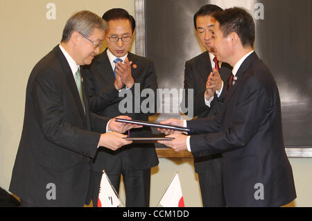 13 novembre 2010 - Yokohama, Japon - Ministre sud-coréen des Affaires étrangères Kim Sung-hwan (L) et le Ministre japonais des affaires étrangères Seiji Maehara (R) échange les documents signés alors que le président sud-coréen Lee Myung-bak (2L) et le Premier ministre japonais Naoto Kan (2R) montre lors de la cérémonie à l'occasion du sommet de l'APEC. Banque D'Images