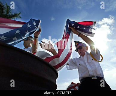 061404 PALM BEACH GARDENS - American Legion # 371 membres Duc Peters, gauche, et Joe Lofredo, place vieilles boîtes en flammes les drapeaux pendant la cérémonie de la retraite de la célébration du Jour du drapeau à Palm Beach Gardens City Hall le lundi. L'événement comprenait le Palm Beach Gardens de police et d'incendie, de sorte que la garde d'honneur Banque D'Images