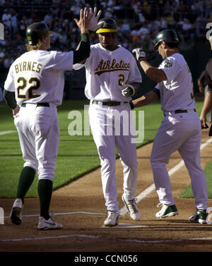 (Centre) Jermaine dye de l'Oakland Athletics est accueilli à la maison par (de gauche à droite) Eric Byrnes et Eric Chavez après qu'il a frappé un coup de circuit, la conduite dans les deux, contre les White Sox de Chicago en première manche le vendredi 16 juillet 2004 à Oakland, Californie l'athlétisme a gagné le match 5 à 1. (Temps de Contra Costa/ G Banque D'Images