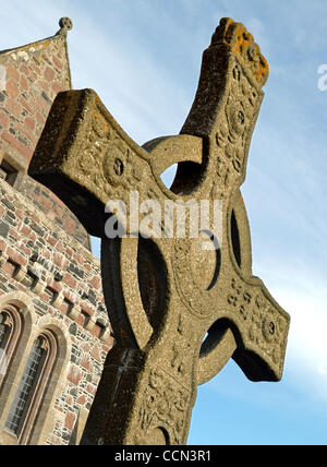 Une grande croix celtique se dresse majestueusement à l'extérieur de l'abbaye d'Iona petite Isle d'Iona au large de la côte ouest de l'Écosse. Saint Colomba, qui a fondé les monastères en Irlande, s'installa sur la petite île en 563 AD, ce qui porte le christianisme en Ecosse et estabilishing ce qui allait devenir l'Église d'Écosse. ©Robin N Banque D'Images