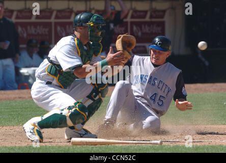 Kansas City Royals Aaron Guiel est en sécurité à la maison comme Oakland Athletics catcher Adam Melhuse attend les deux pas de droit fielder Jemaine colorant dans la 8e manche de leur jeu à Network Associates Coliseum Dimanche Août 15,2004.(Contra Costa Times/Bob Larson) Banque D'Images