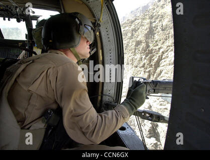 Aug 27, 2004 ; Kandahar, Afghanistan ; un mitrailleur sur un hélicoptère Blackhawk numérise l'Afghanistan des montagnes pour une activité suspecte au cours d'un vol de base de feu Ripley à Kandahar, en Afghanistan. Banque D'Images