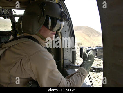 Aug 27, 2004 ; Kandahar, Afghanistan ; un mitrailleur sur un hélicoptère Blackhawk numérise l'Afghanistan des montagnes pour une activité suspecte au cours d'un vol de base de feu Ripley à Kandahar, en Afghanistan. Banque D'Images