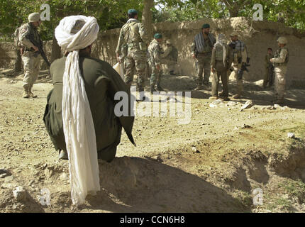 Aug 27, 2004 ; Kandahar, Afghanistan ; les membres de l'Armée nationale afghane de l'armée américaine et discuter de ce qu'il faut faire avec un homme après qu'il a été pris avec deux AK-47's non enregistrés dans un sac. Où les armes confisquées et l'homme laisser aller. Banque D'Images