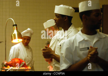 METRO-spécialiste culinaire Maître de 2e classe Xena Fryer, de gauche, spécialiste culinaire recruter marins Ryan Jordan, spécialiste culinaire Eric Whitaker marins et marins spécialiste culinaire apprenti, Andrew Johnson, attendre pour servir l'action de grâce qu'ils ont préparé à Lackland Air Force Base à San Banque D'Images