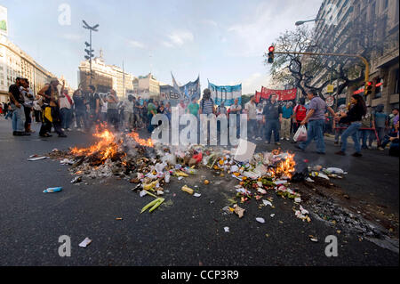 Oct 21, 2010 - Buenos Aires, Argentine - lumière manifestants corbeille sur le feu, tout en bloquant le 9 juillet que les manifestants convergent vers la Place de mai à Buenos Aires, Argentine, en signe de protestation contre la mort de Mariano Ferreyra, 23, au cours d'une manifestation au cours de la mise à pied de former les employés à partir de la linea de la Roca Banque D'Images