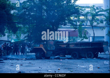 Un parc de camions brûlés au milieu de la route tandis que les journalistes et les chemises rouges se peotesters couvrir de tireurs embusqués sur les deux côtés de la route. Des barricades de pneus ont été mis en place autour de Din Daeng intersection par Red Shirts manifestants comme l'intersection a été sous le feu de tireurs cachés dans près de b Banque D'Images