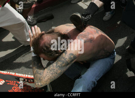 Demonstraters au comptoir pro rallye néo-nazi, battre et kick un homme avec des tatouages nazis au cours d'un rassemblement néo-nazi pro à l'hôtel de ville de Los Angeles CA. 17 avril, 2010. (Dave Waters) Banque D'Images