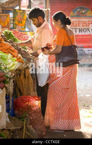 7 mai 2010, Mumbai, Inde - un homme aide un vendeur de légumes à sa femme sélectionnez échoppe de marché dans la communauté de Chembur Mumbai, Inde. (Crédit Image : David Snyder/ZUMAPress) Banque D'Images