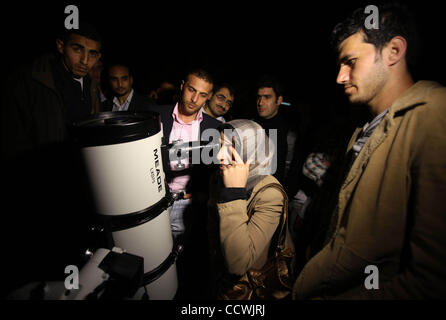 Apr 29, 2010 - La ville de Gaza, bande de Gaza - une femme palestinienne regarde à travers un télescope au cours d'une conférence donnée par l'astrophysicien palestinien S. Baraka, au Centre Culturel Français dans la ville de Gaza. Baraka, un astrophysicien, chercheur et expert de la météo spatiale à la NASA, a été soulevée de l'humble beginni Banque D'Images