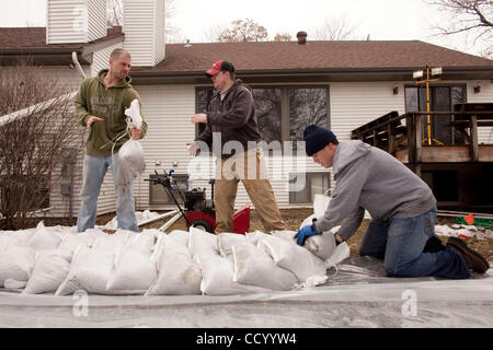 15 mars 2010 - Oxbow, Dakota du Nord, USA - Bryce Olson, gauche, et Kyle, Förster Appartements centre, de sable pour passer à son propriétaire Joe Sauvegeau Oxbow, Dakota du Nord Accueil Lundi, 15 mars 2010 à titre de bénévoles construire une digue de protection à partir de la crue des eaux de la rivière Rouge. Une grande partie de la ville d'Oxbow a été floode Banque D'Images