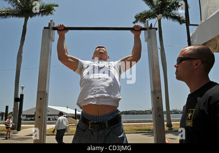 050408 rencontré sunfest 3 photo par Steve Mitchell/Le Palm Beach Post-0052509Une histoire de Paul Quinlan- Jay Esteras (CQ) de NJ, qui est répertorié dans le United States Marine Corps travaille sur son pull ups comme spécialiste de l'Armée de Jason sur Ft. Bragg, Caroline regarde au cours de la dernière journée de Sunfest le dimanche, Banque D'Images