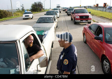 Agent de police de La Nouvelle-Orléans Reginald Cook (R) parle avec la Nouvelle-Orléans l'ouragan Gustav évacué Marty Rollins à un barrage routier sur l'Interstate 10 au lac Pontchartrain Causeway à New Orleans, Louisiane, USA le 03 septembre 2008. Seulement quelques minutes plus tard la police a pris les roadbloack, permettant à tous les retouri Banque D'Images