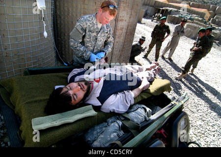 Apr 18, 2008 - La province de Paktya, Afghanistan - l'un des deux chauffeurs de camions Afghans blessés lors d'une embuscade d'insurgés conçu pour détourner les camions et les mettre en feu est assisté par Jean Giasullo PFC infirmier de l'armée à la base d'opérations avancée désert, l'Est de l'Afghanistan. L'Aghan est fixé sur un Gator pour Banque D'Images